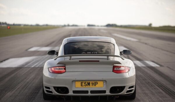 Rear view of a white Porsche on a runway.