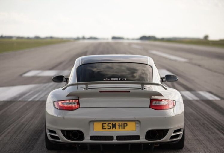 Rear view of a white Porsche on a runway.
