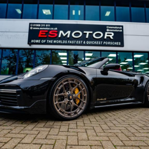 Black Porsche Turbo S parked in front of ESMotor building.