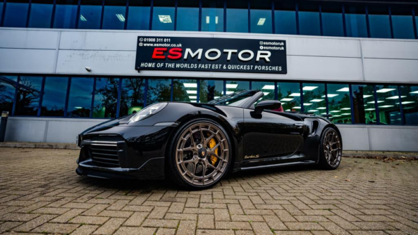 Black Porsche Turbo S parked in front of ESMotor building.