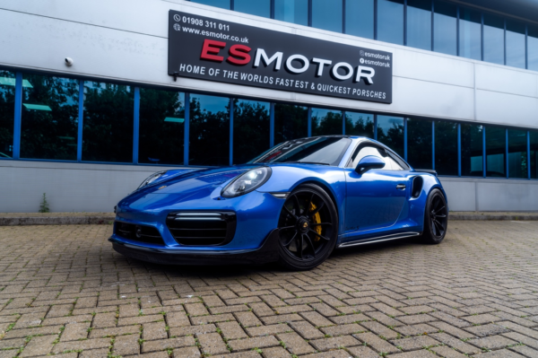 Blue Porsche ES1100 parked outside ESMotor garage.